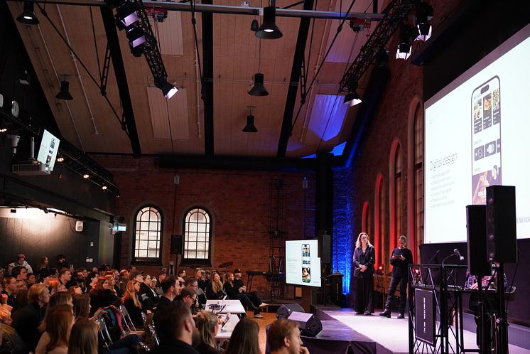 Studenter pitchar på scenen