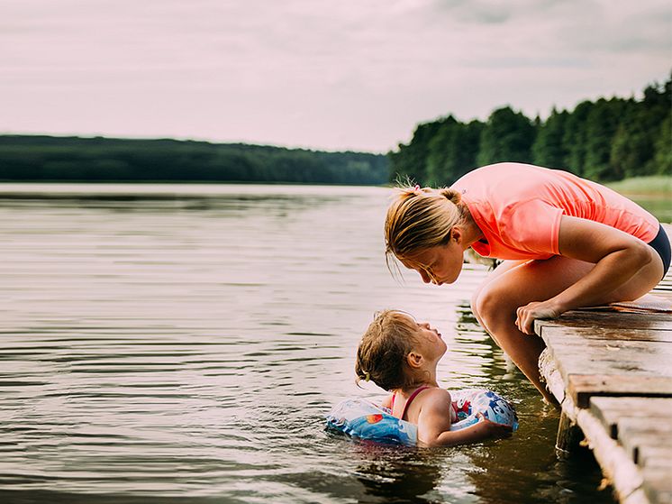 Kvinna_på_brygga_med_dotter_i_vattnet_höger_webb