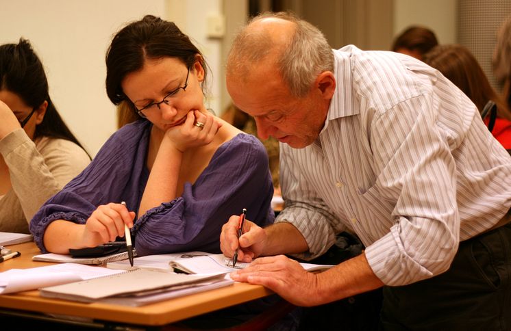 Volontär och elever försöker lösa ett matematiskt problem under Mattecentrums räknestuga