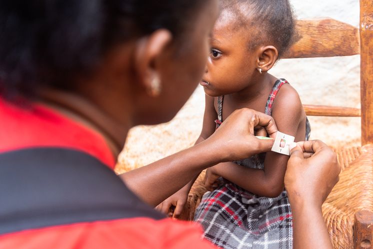 CH1838505_Rose Nalda measures Withmaly's arm for signs of malnutrition