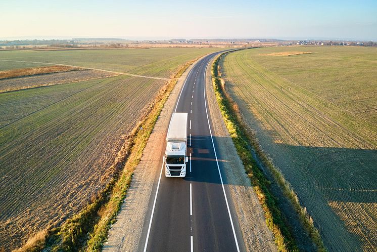 aerial-view-blurred-fast-moving-semitruck-with-cargo-trailer-driving-highway-hauling-goods-evening-delivery-transportation-logistics-concept