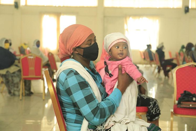 Zenebech* mother of three with her youngest at an emergency food assistance gathering.