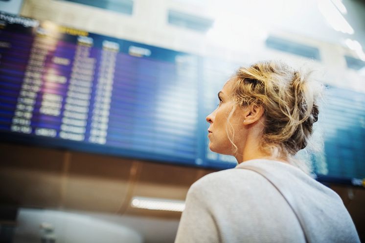 Resenär tittar på tavla för avgångar och ankomster på en av Swedavias flygplatser.