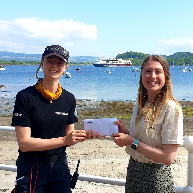 Vivi Bolin, Science & Education Coordinator on board MS Maud, presents Caroline with the donation_Credit_Hebridean Whale and Dolphin Trust