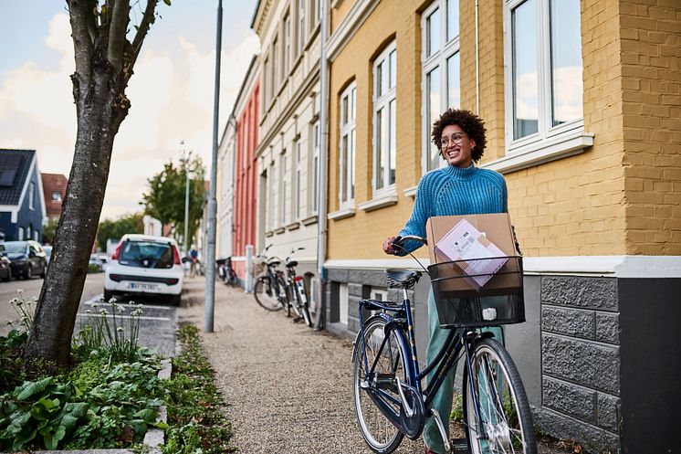 Kvinde med cykel afhenter GLS pakker