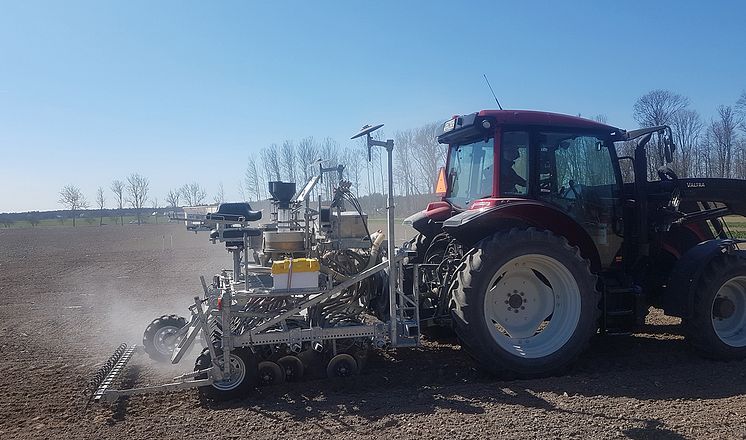 Traktor sprider den torkade växtnäringen