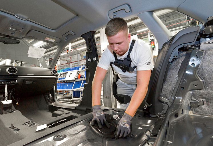 An Audi employee wears the exoskeleton to relieve the back muscles when installing the interior trim during A4 and A5 assembly at the Ingolstadt plant