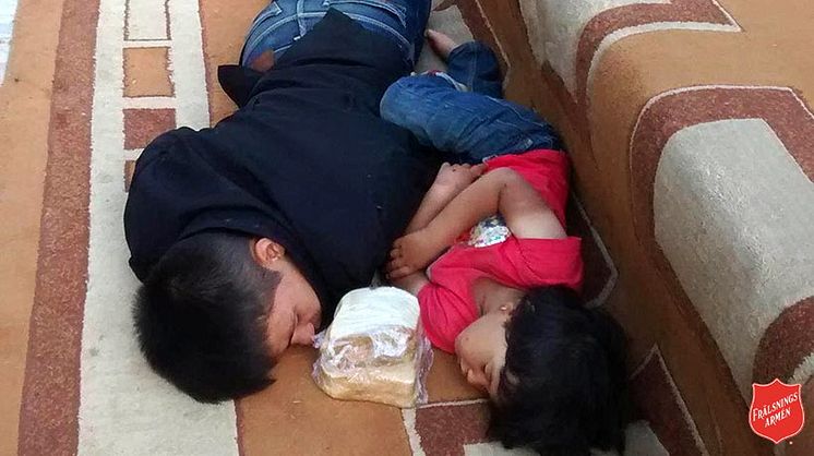  Flyktingbarn som sover på en matta under en parkbänk i Aten. Frälsningsarmén har lagt smörgåsar till dem att äta när de vaknar upp. 