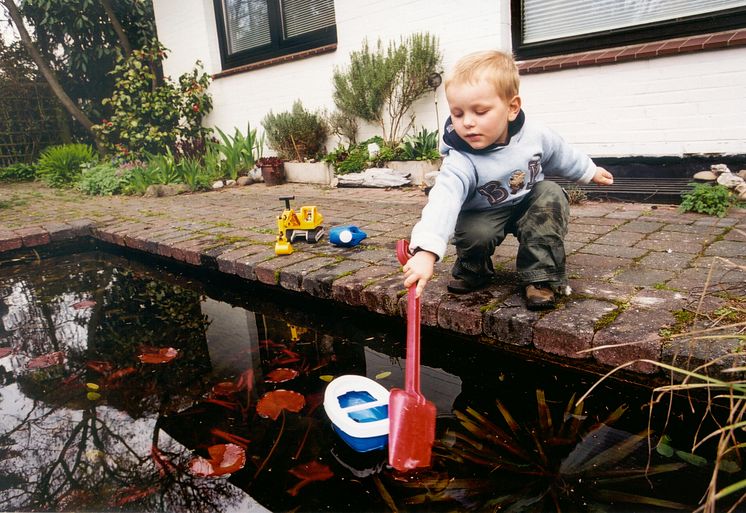 Junge am Gartenteich