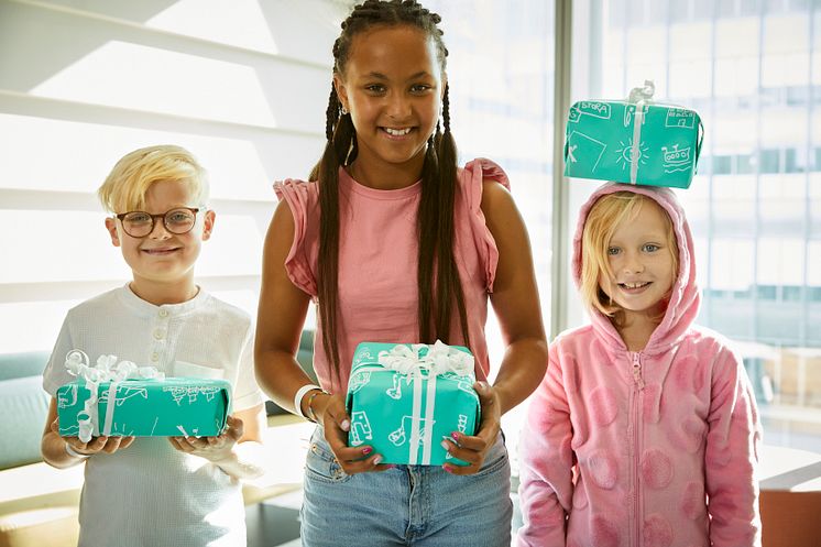 Melker, Elsa och Elias med inslagna paket. Fotograf Magnus Ragnvid