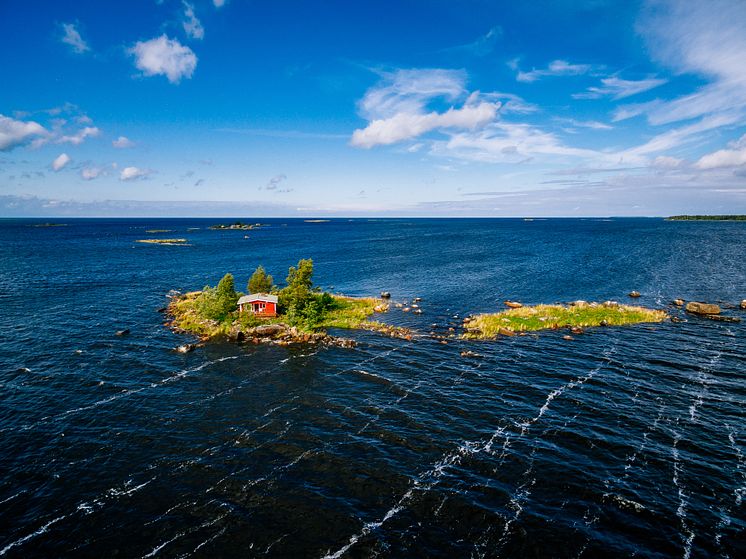 Röd stuga mitt ute i havet.jpg