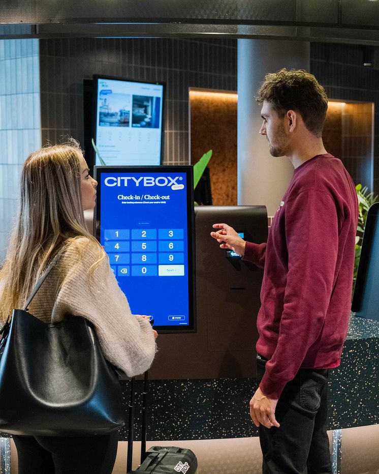 Host helping guest check in to Citybox Helsinki
