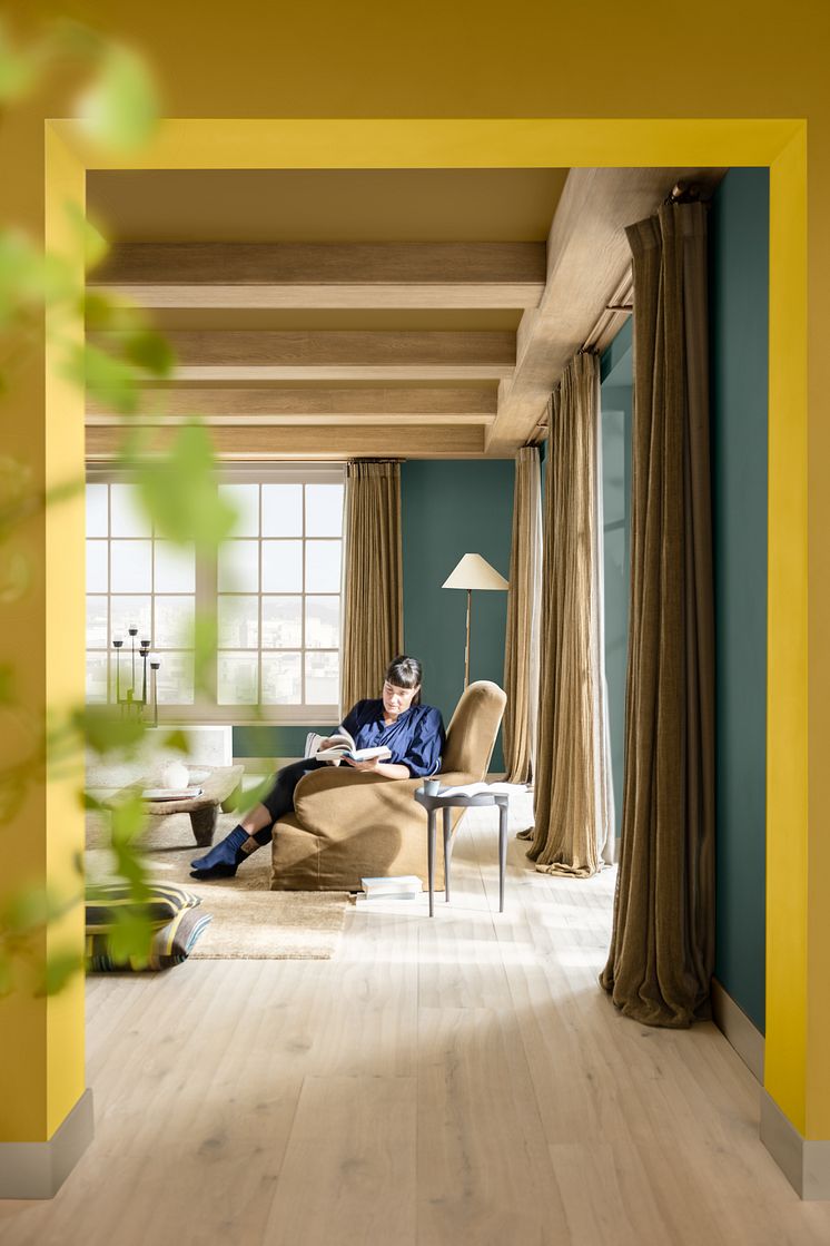 Flexa-Kleurentrends-2025-Kleur-van-het-Jaar-2025-True-Joy-Trots-woonkamer-doorkijk-persoon.jpg