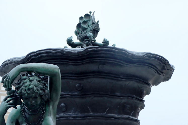 Järntorgsbrunnen, i förgrunden detalj Oceanien, i bakgrunden skeppet på toppen av järnurnan Bild Göteborgs Stad.png
