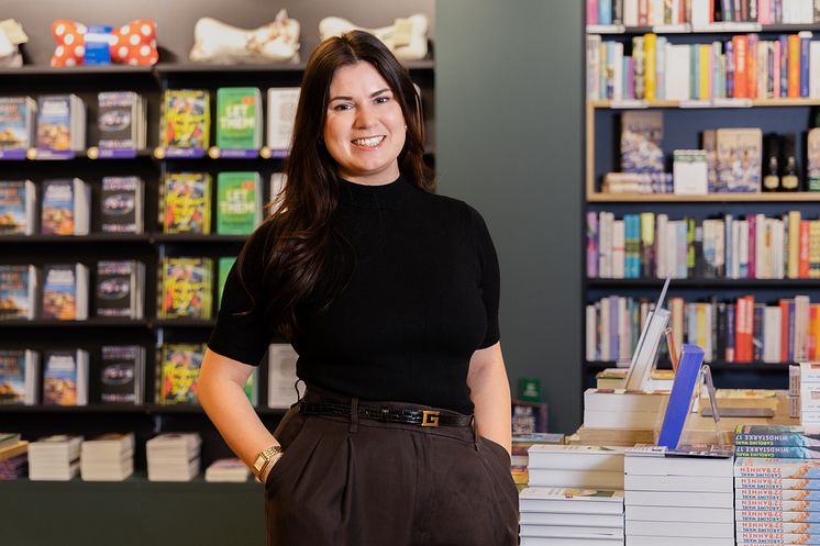 Porträt von Chiara Grassauer, der Leitung der Thalia Buchhandlung Simmering, inmitten von Büchern.
