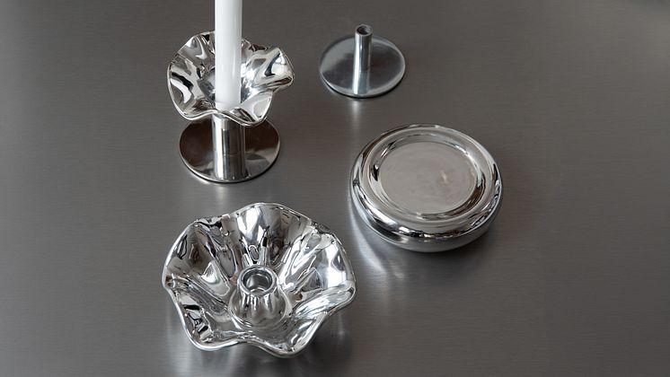 Närbild av eleganta inredningsdetaljer i blankpolerad krom på ett rostfritt bord. 