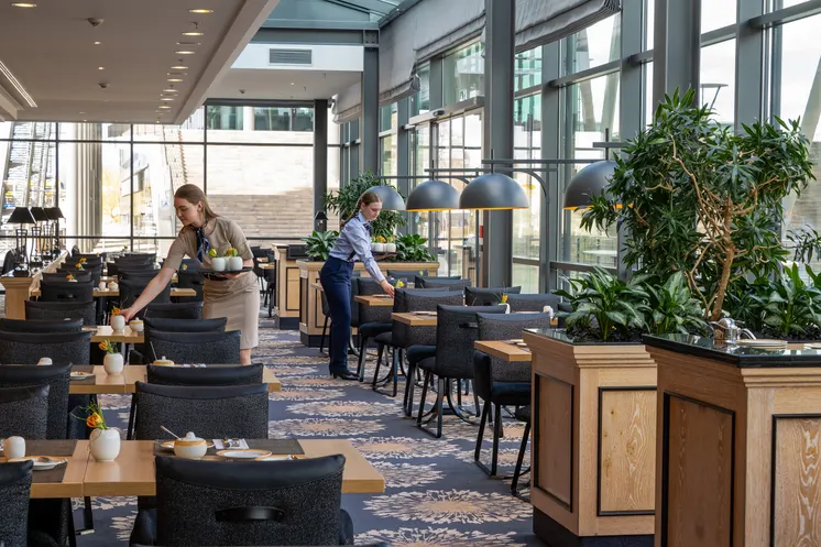 Tische im Restaurant werden von zwei Mitarbeiterinnen eingedeckt