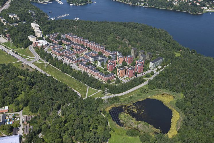 Flygfotomontage med ny bebyggelse i mörkröda/gröna kulörer. Illustration: Murman Arkitekter.