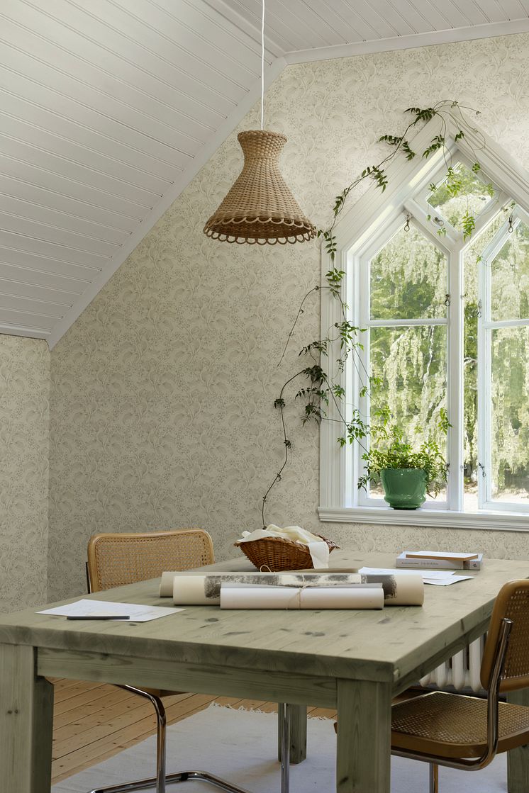 Beige tapet med mönster av syrénkvistar i kreativt arbetsrum. 