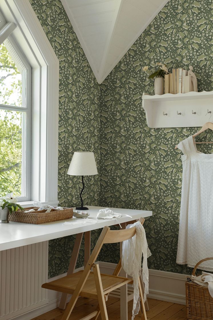 Grön tapet med syrénkvistar i en ljus syhörna.