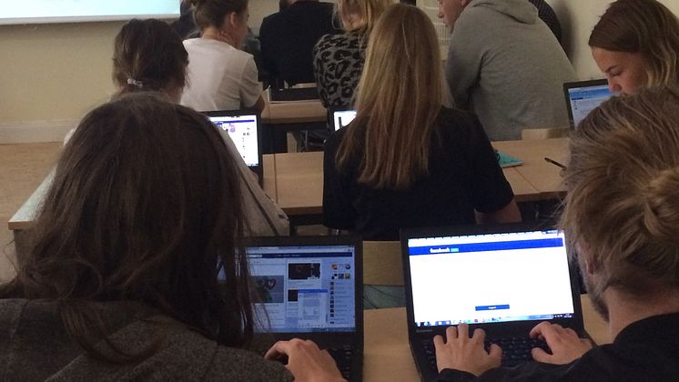 En grupp gymnasister vid varsin datorskärm, sedda bakifrån.