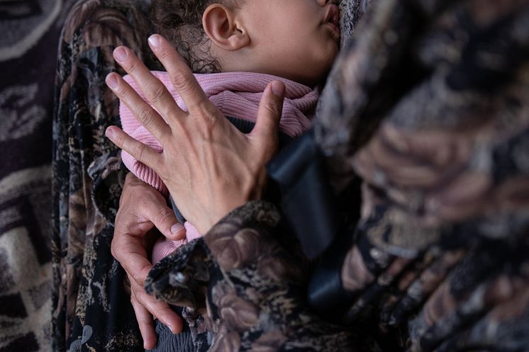 CH11049611_Yasmeen (40) holds her daughter Heba (19 mth) in their tent in Gaza.jpg