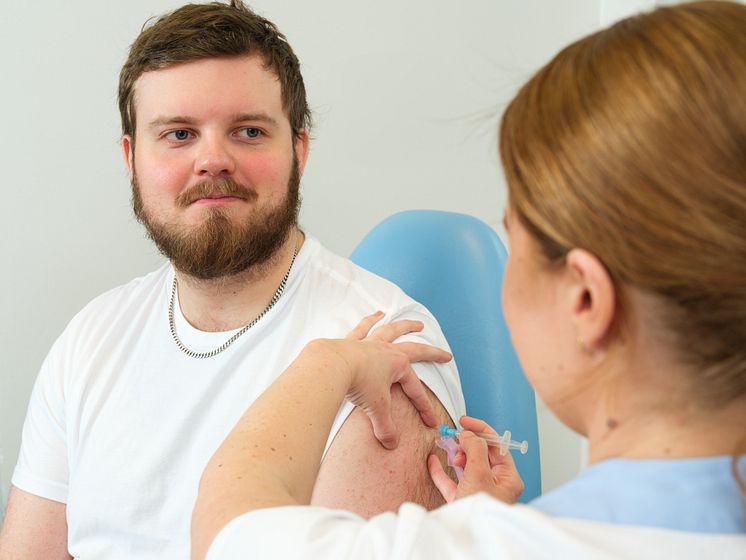 Ung man som får vaccin.