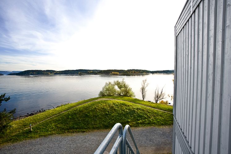 Utsikt från modulär byggnad vid vattnet, symboliserar Adapteos hållbara satsningar.