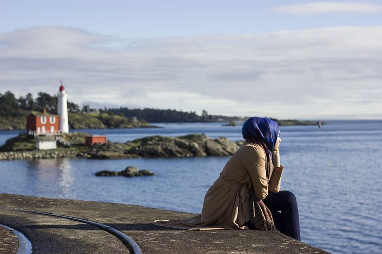 Ung kvinna med hijab blickar ut över en sjö.jpeg