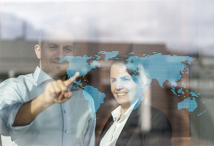 Personen_vor_digitaler_Weltkarte,_Unternehmensnetzwerk,_internationale_Märkte.jpg