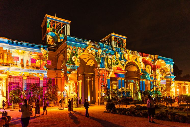 Orangerie Schloss Potsdam, mit bunten Bildern beleuchtet.