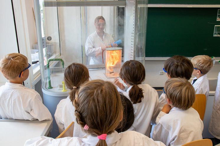 Gespanntblicken die Kinder auf das Experiment im Chemielabor