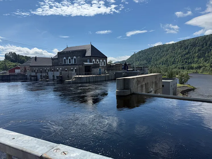 Kraftstasjon, vann fra elv og skog i bakrgunnen