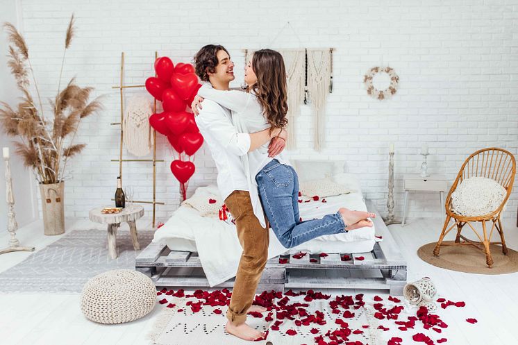 full-length-shot-young-man-holding-his-girlfriend-hands-room-decorated-with-rose-petals-st-valentines-day.jpg