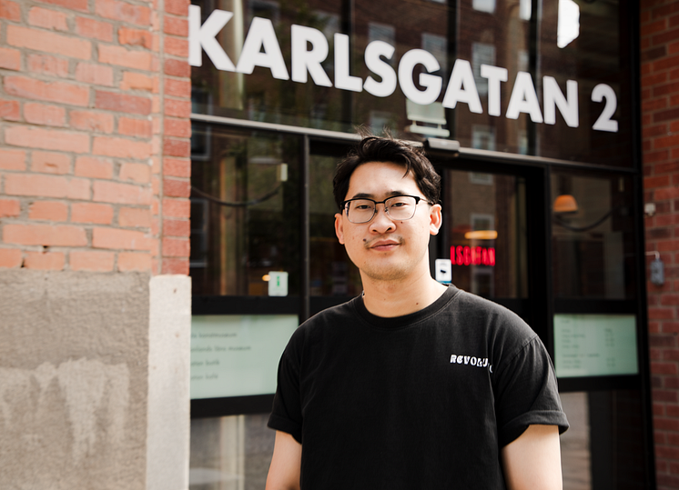 Konstnären Sai utanför entrén till Karlsgatan 2 i Västerås.