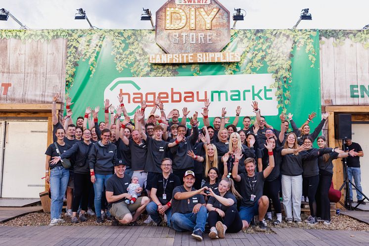 Das 61 köpfige hagebau Team vor dem hagebaumarkt DIY-Store by Swertz auf der Campsite bei dem Parookaville Festival 2025