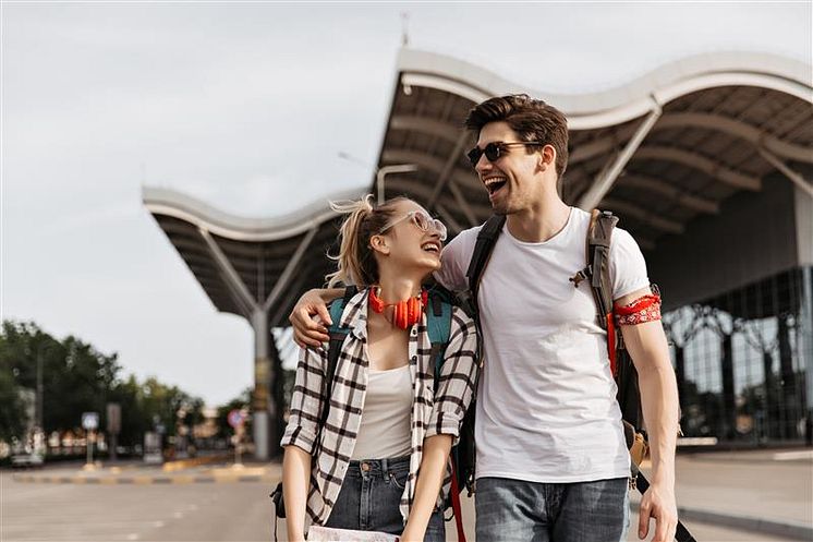 cheerful-man-woman-sunglasses-laughs-near-airport-guy-girl-white-tshirts-hold-map-backpacks.jpg
