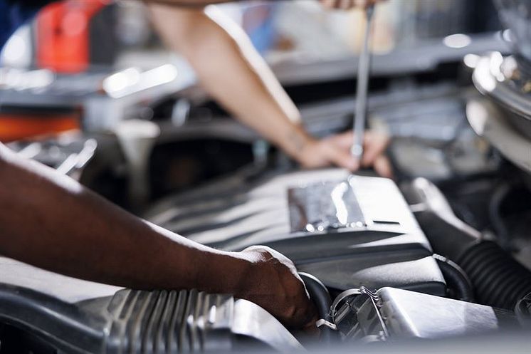 mp63563296-garage-coworkers-fix-car-engine.jpg