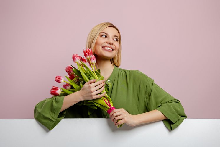 beautiful-young-blond-hair-woman-holding-bunch-tulips-against-pink-background.jpg