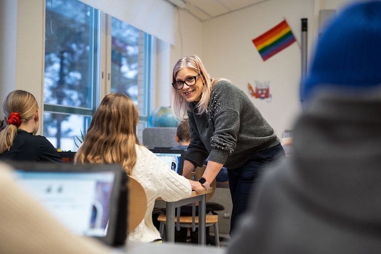 Lärare och elever i klassrumsmiljö. 