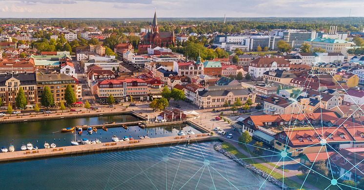 Helikopterbild över Västervik med grafiska element av blå punkter med streck mellan. Visar mobil konnektivitet. 