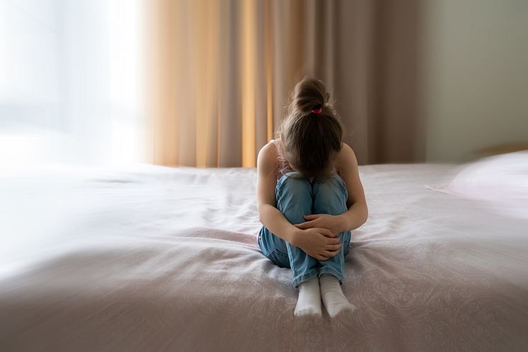 mp56230385-a-little-sad-girl-sitting-on-a-bed-with-motion-blur-effect.jpg