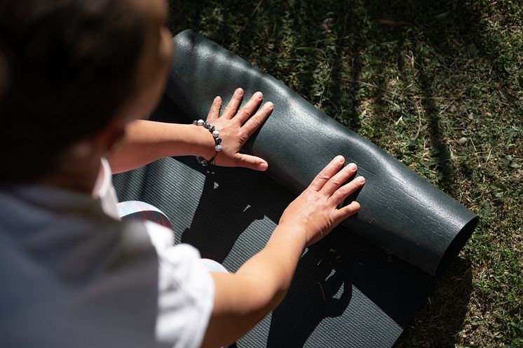 mp65119611-close-up-of-a-person-rolling-up-a-yoga-mat-outdoors.jpg