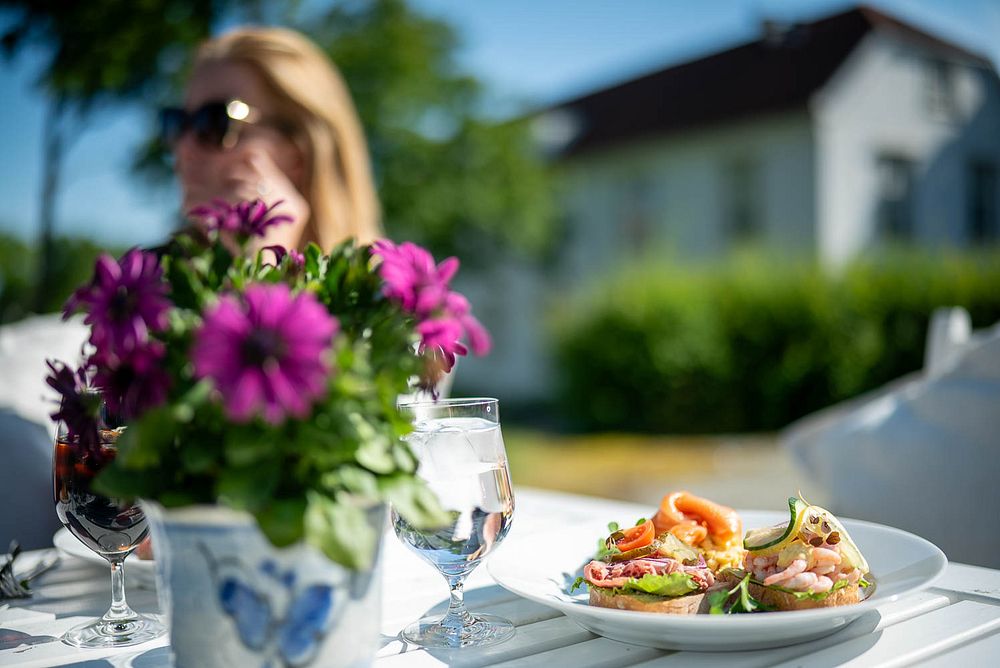 Sommergjester nyter smørbrød i hagen – omgitt av ro og herskap.