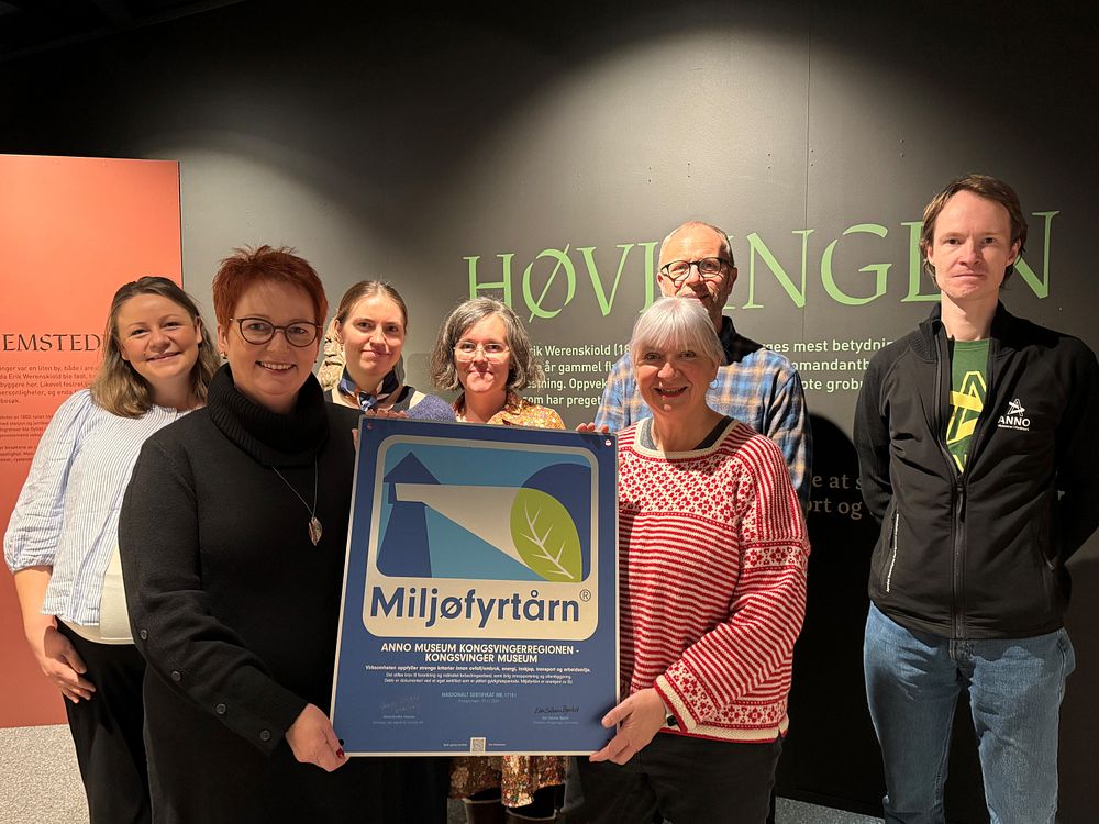 En gruppe mennesker, der to kvinner i front holder en plakett med miljøfyrtårn.