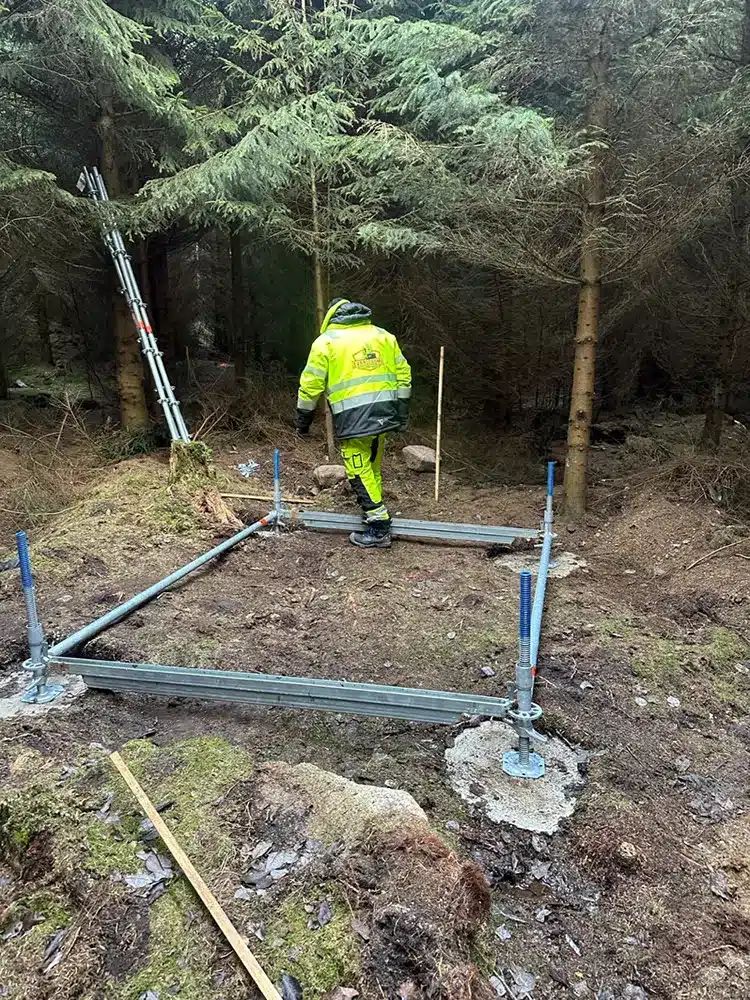 Ställningsmontör förankrar byggställning i berget.