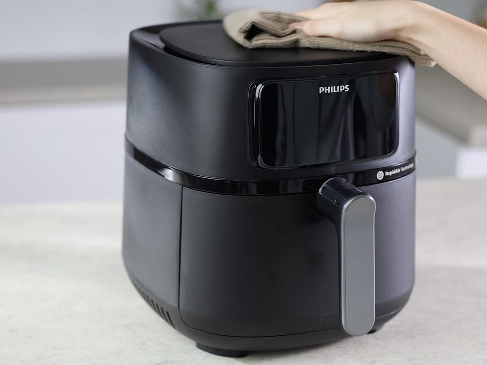 Utsidan av en Philips Airfryer rengörs med en trasa