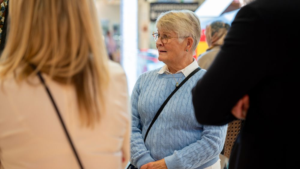 En grupp människor som står och pratar med varandra.
