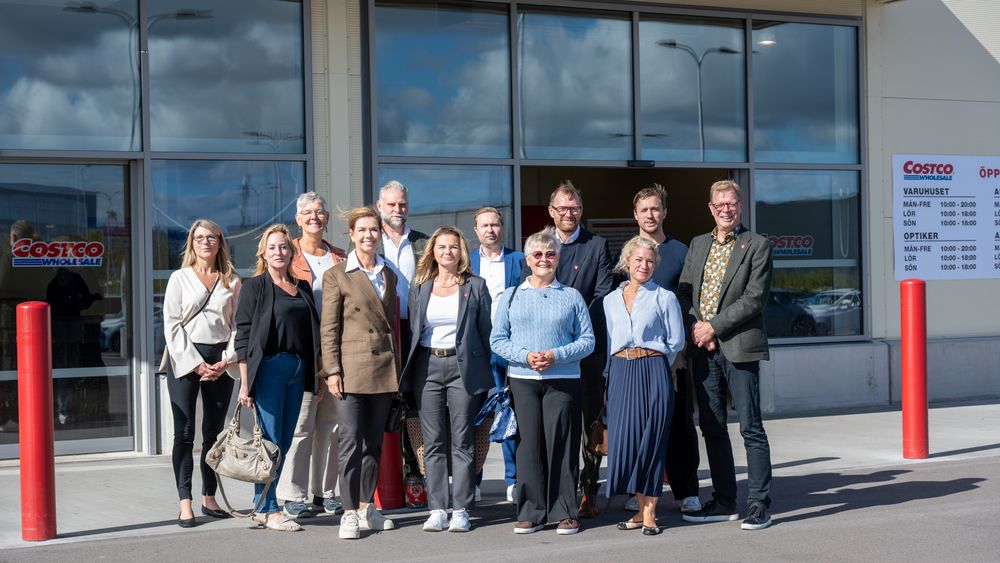 En grupp människor som står framför en byggnad.