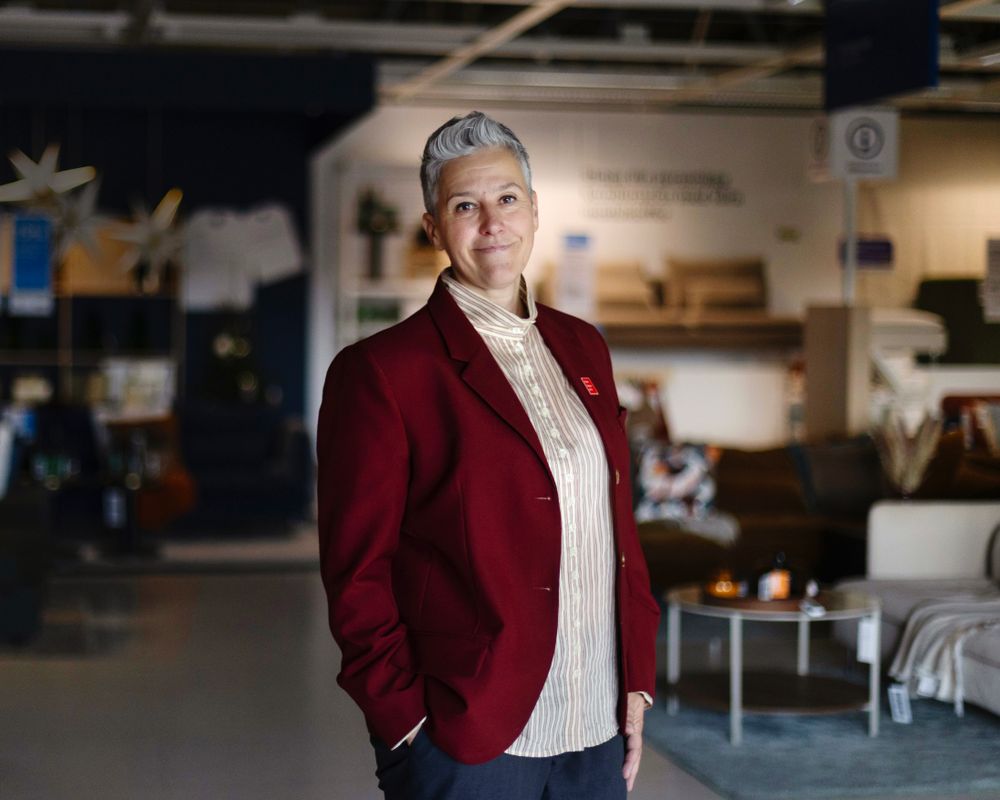 En kvinna i röd kavaj står i ett IKEA-varuhus.